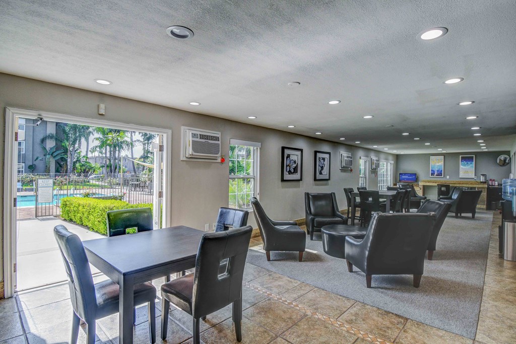 a dining area with tables and chairs and a view of a pool