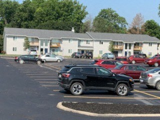a parking lot filled with cars in front of apartments