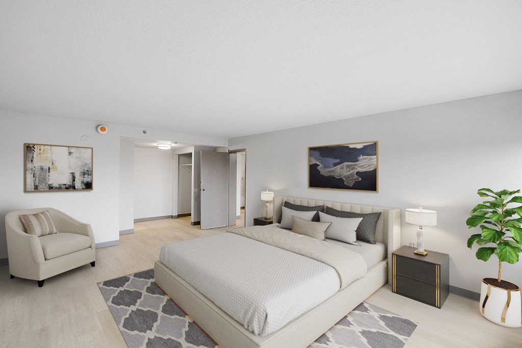 a bedroom with a bed and a chair in a 555 waverly unit at The Block at Sterling Heights, Sterling Heights, MI, 48312