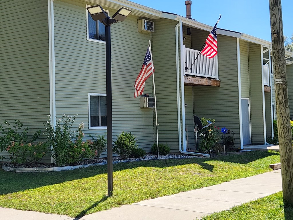 a house with two american flags in the front yard