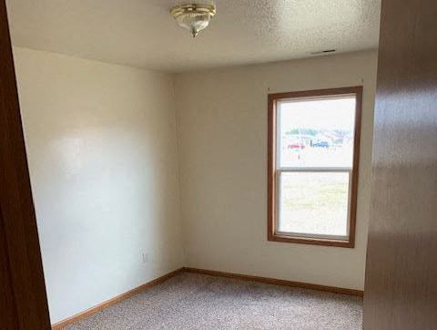an empty room with a window and a ceiling fan