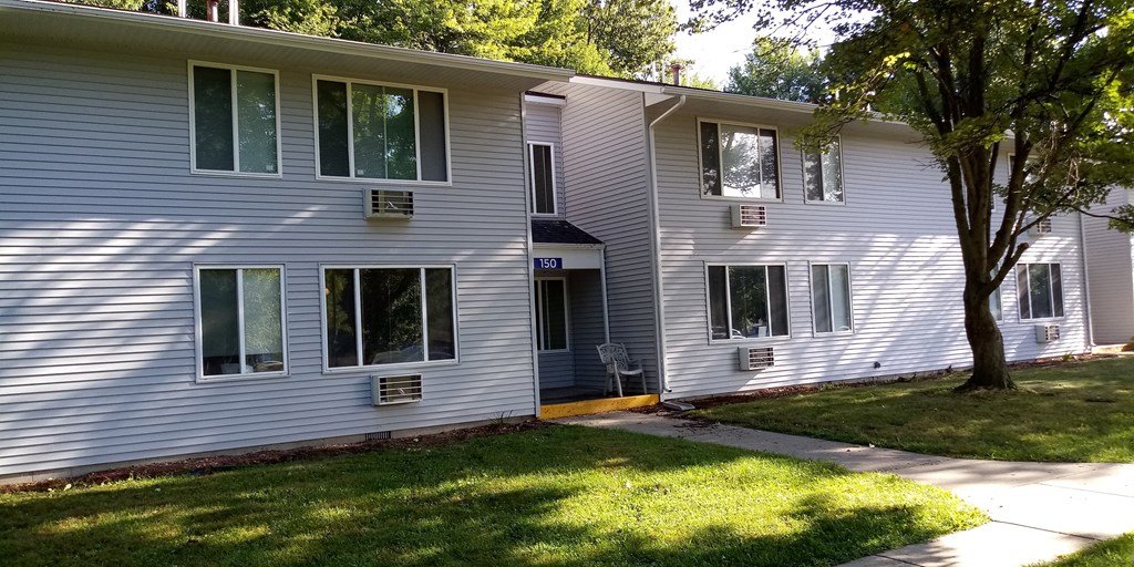 a white house with a yard and a tree