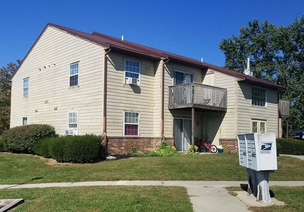 a yellow house with a balcony and a meter in front of it