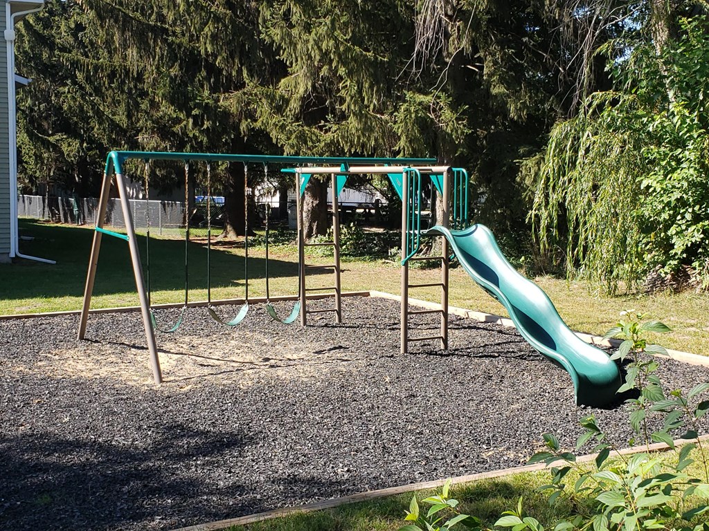 a swing set with a slide in a park