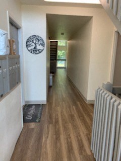 a hallway with white walls and a wood floor