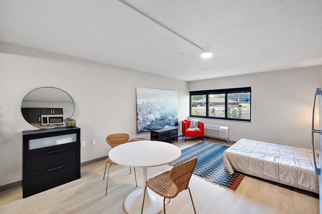 a bedroom with a bed and a table and chairs at The Block at Sterling Heights, Michigan, 48312