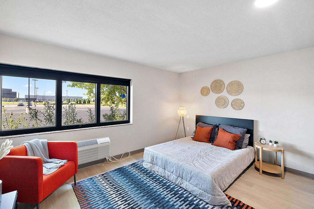a bedroom with a large window and a large bed at The Block at Sterling Heights, Sterling Heights, MI