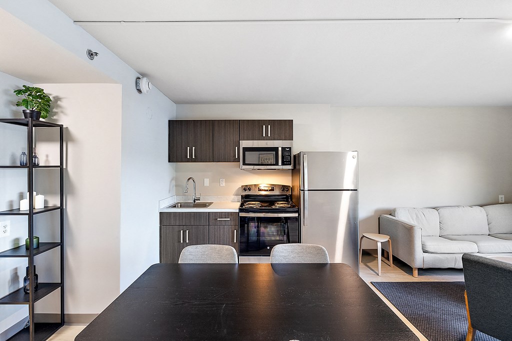 a kitchen and living room in a 555 waverly unit at The Block at Sterling Heights, Sterling Heights, MI