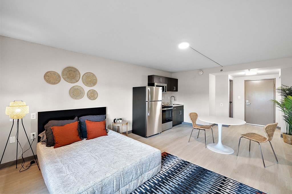 a bedroom with a bed and a table and chairs at The Block at Sterling Heights, Sterling Heights, 48312