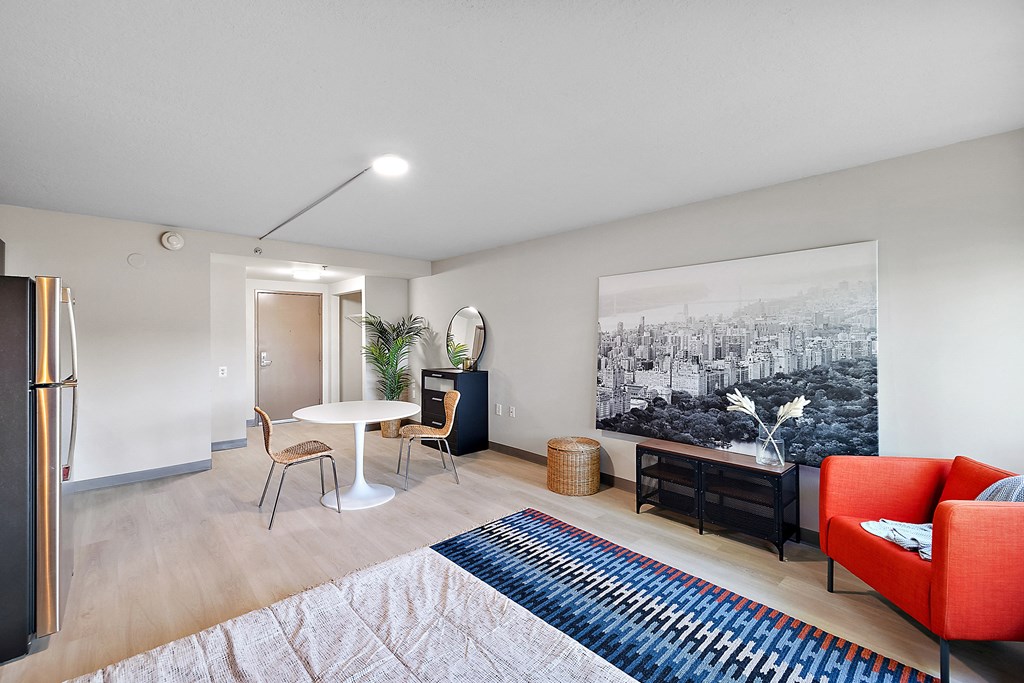 a living room with a couch table and chair and a large painting on the wall at The Block at Sterling Heights, Sterling Heights, Michigan