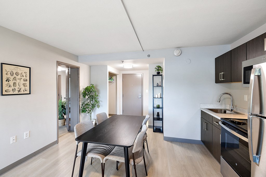 a dining room and kitchen in a 555 waverly unit at The Block at Sterling Heights, Michigan