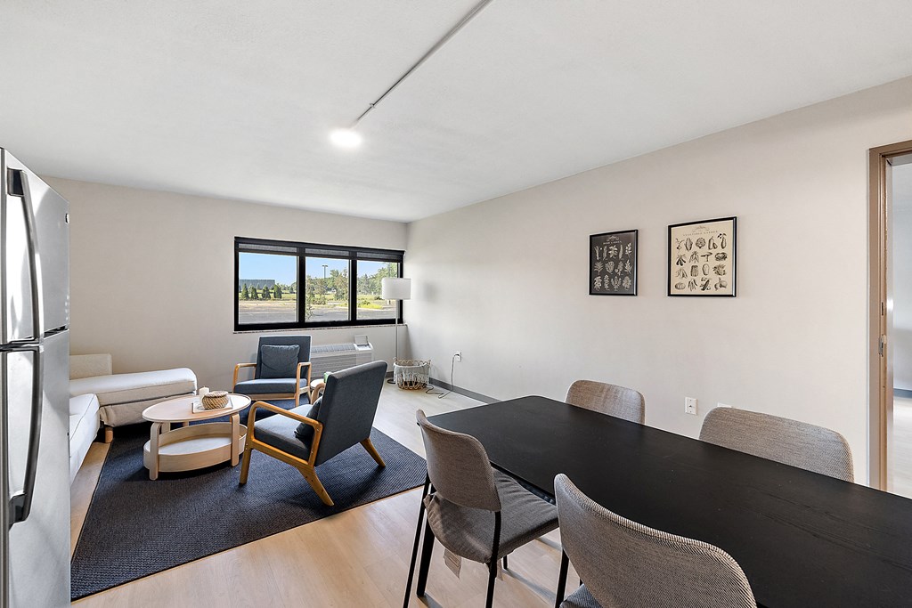 a living room with a black dining table and chairs and a white couch at The Block at Sterling Heights, Sterling Heights, 48312