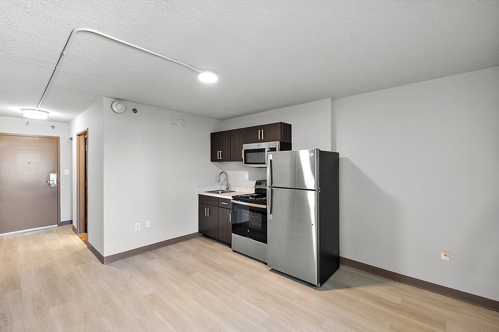 an empty kitchen with a stainless steel refrigerator and stove