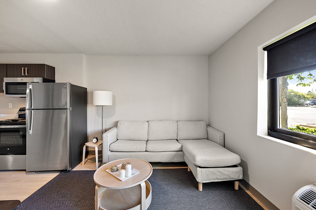 a living room with a couch and a table and a refrigerator