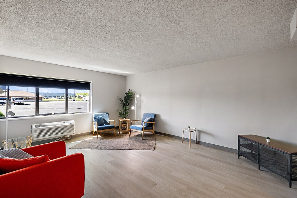 a living room with red furniture and a large window
