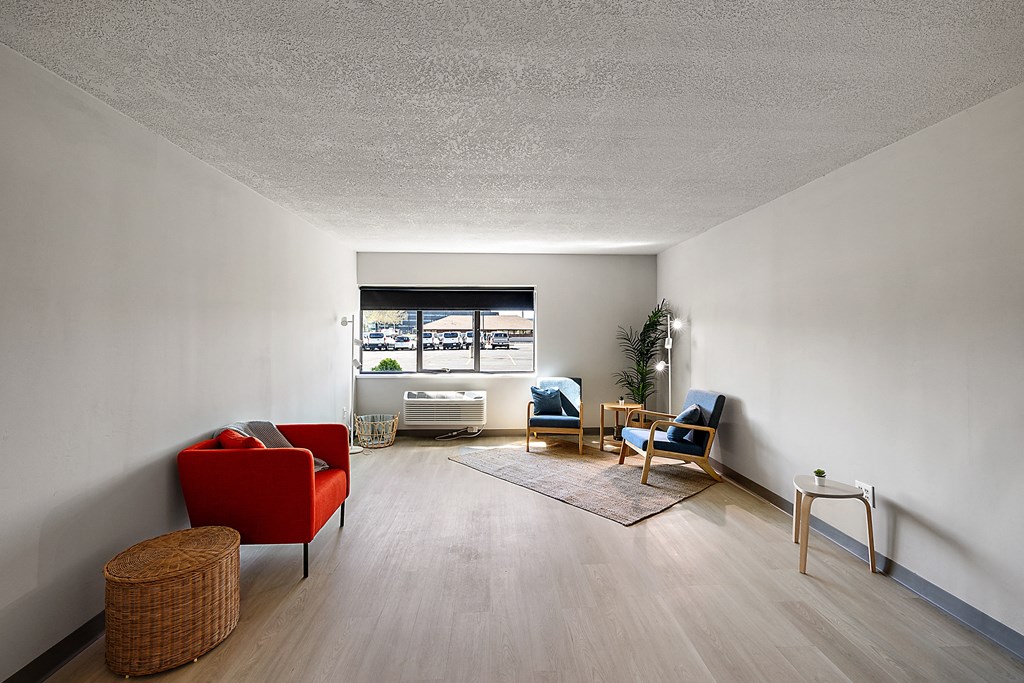 a living room with red furniture and a window