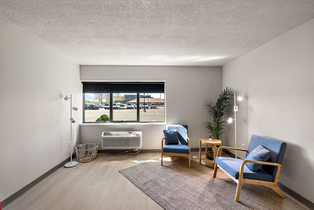 a living room with blue chairs and a window