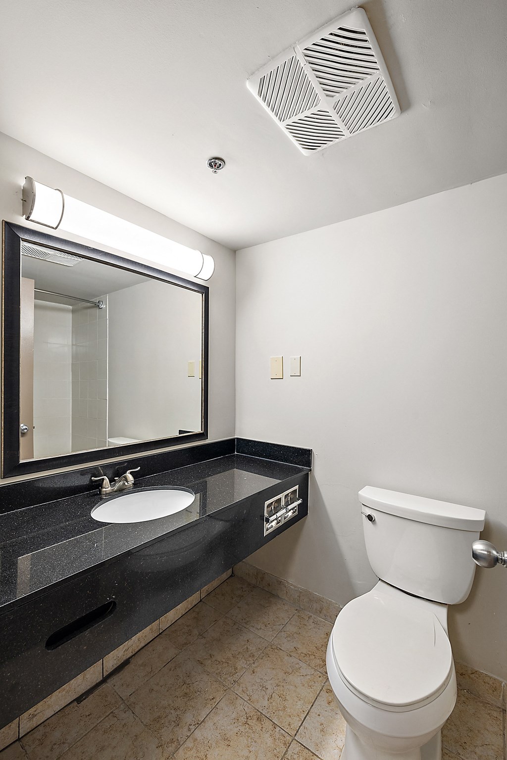 a bathroom with a toilet and a sink and a mirror