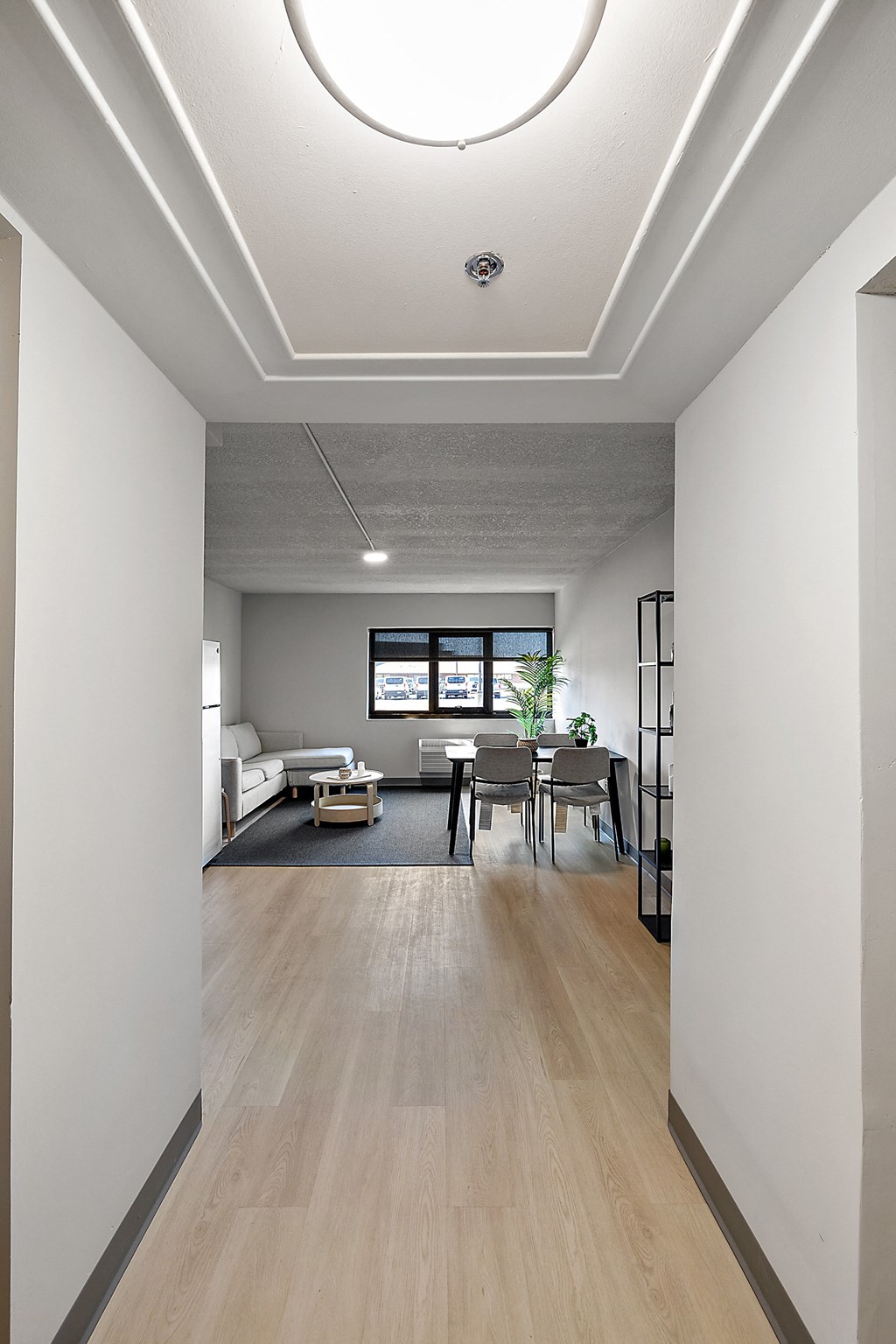 a living room and dining room with white walls and wood floors