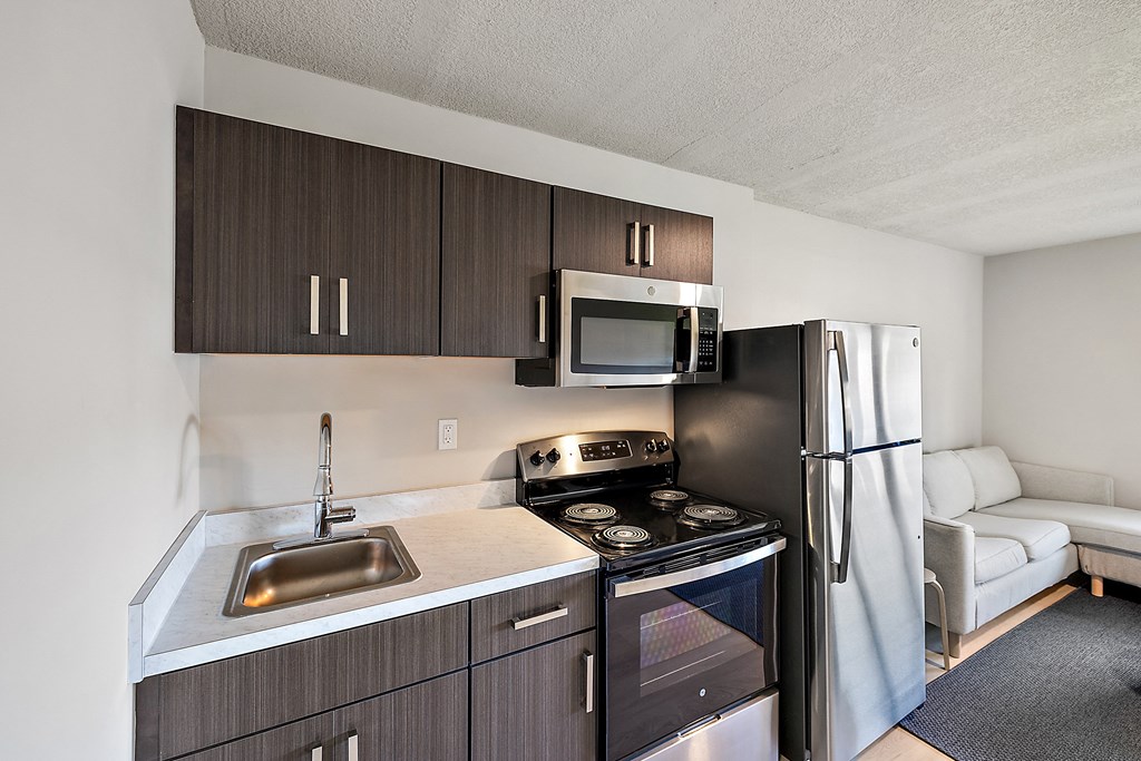 an apartment kitchen with a stove refrigerator and sink