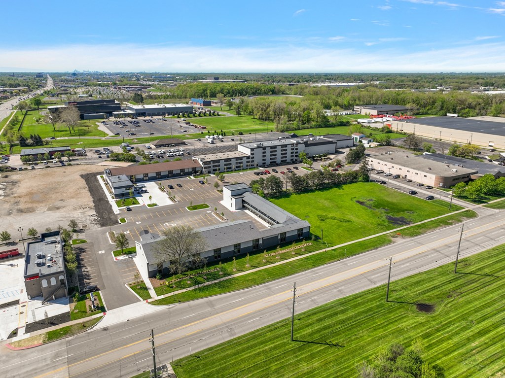 an aerial view of a city with buildings and a green field