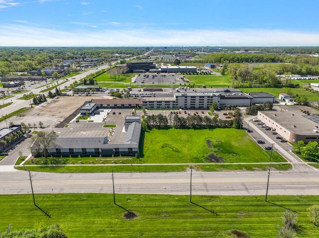 an aerial view of a city with buildings and a green field