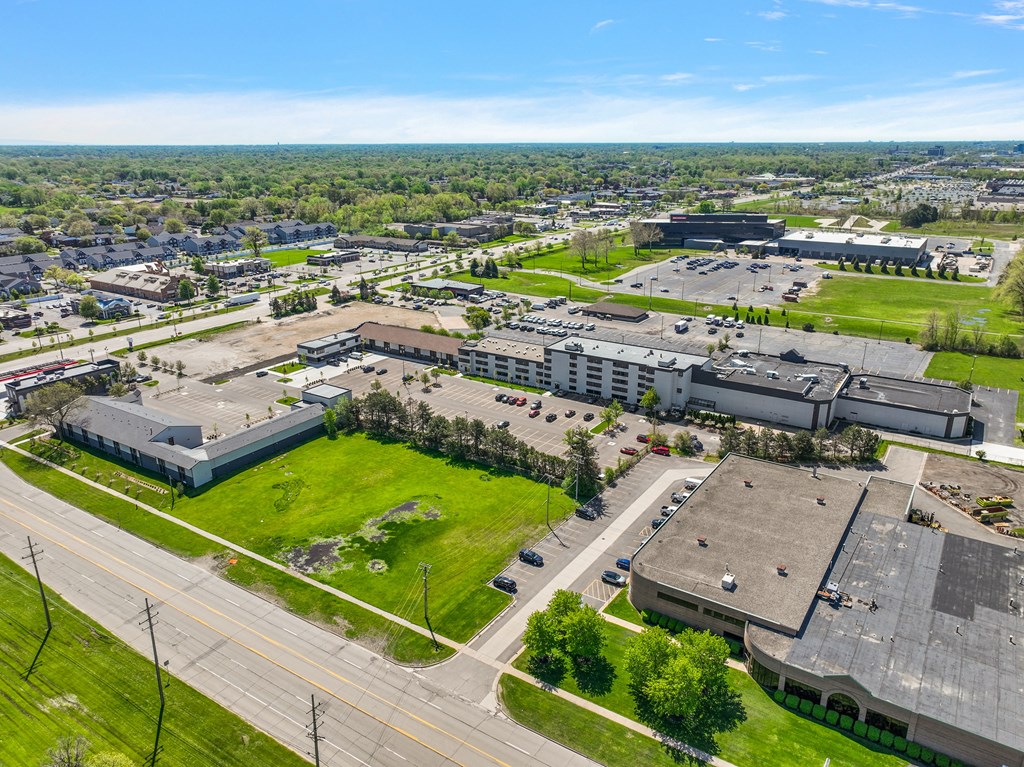 an aerial view of a city with buildings and a green field