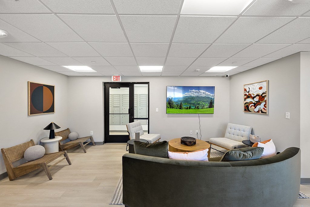 a living room with couches and chairs and a television on the wall