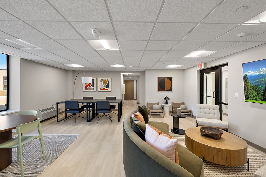 a lounge area with couches chairs and tables in a room