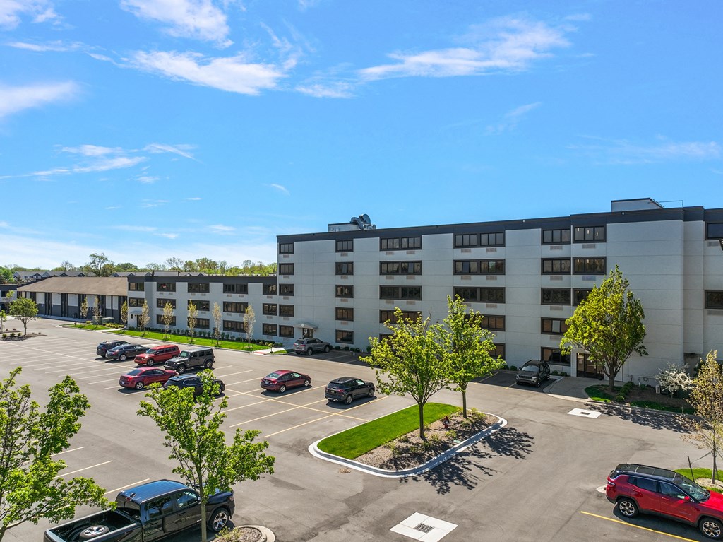a parking lot with cars parked in front of an apartment building