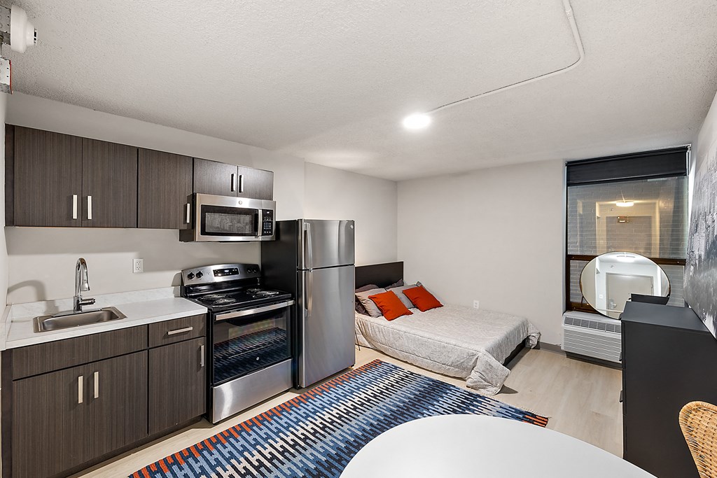 a studio apartment with a kitchen and a bed