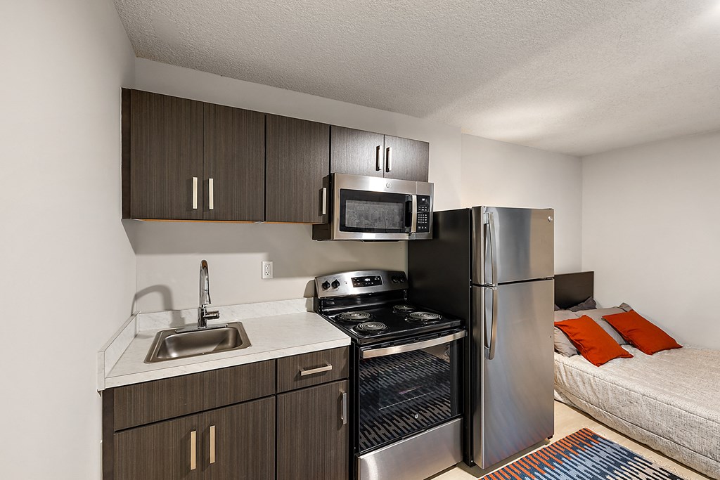 a kitchen with a sink and a refrigerator and a microwave