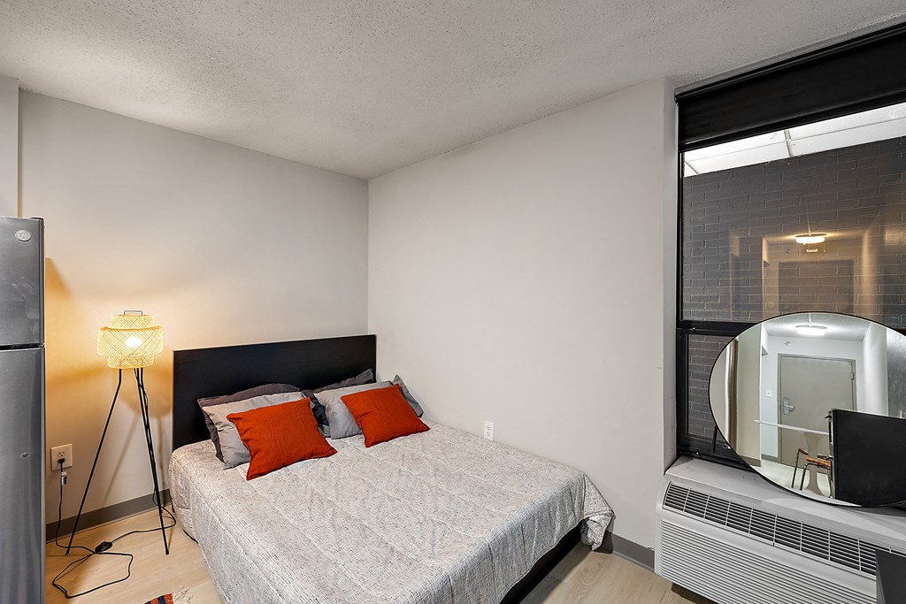 a bedroom with a bed and a large window