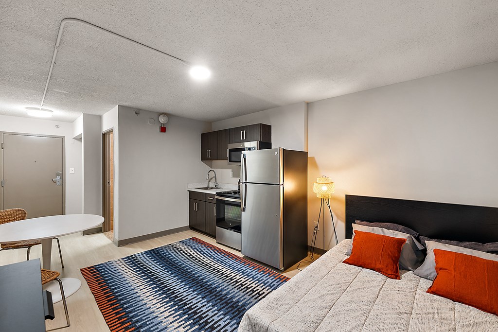 a studio apartment with a bed and a refrigerator