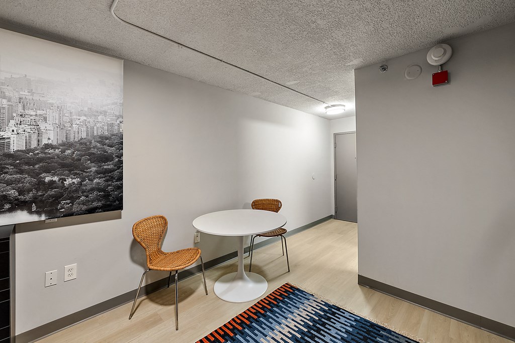 a room with a table and two chairs and a painting on the wall