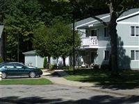 a green car parked in front of a blue house