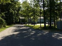 a street with trees and a house in the distance