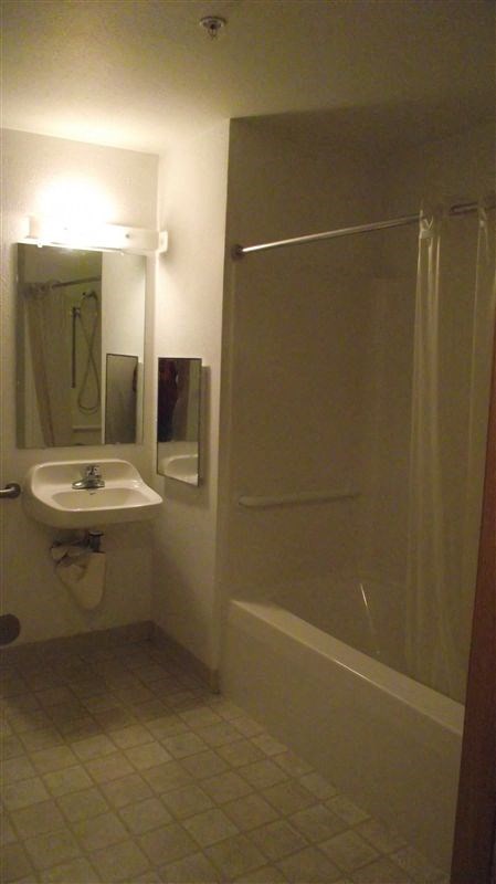 a white bathroom with a sink and a shower