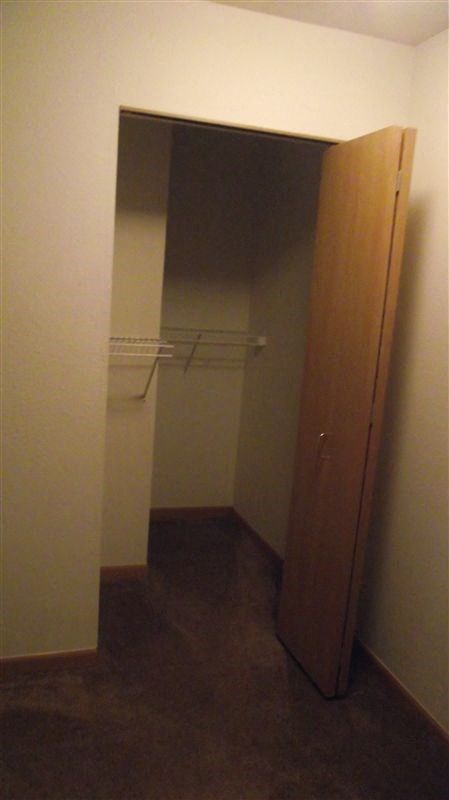 a closet in a small room with a wooden door