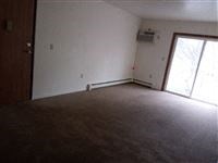 an empty living room with white walls and a window