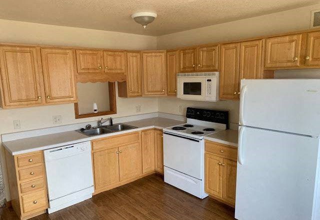 a kitchen with white appliances and wooden cabinets