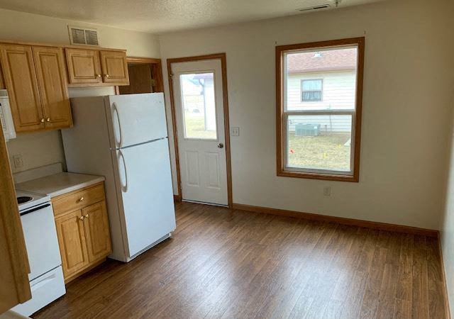 an empty kitchen with a refrigerator and a window