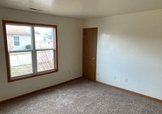 an empty room with a window and a door