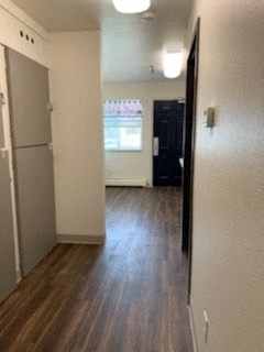 a living room with a hard wood floor and a refrigerator