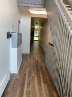 a long hallway with a wood floor and a staircase