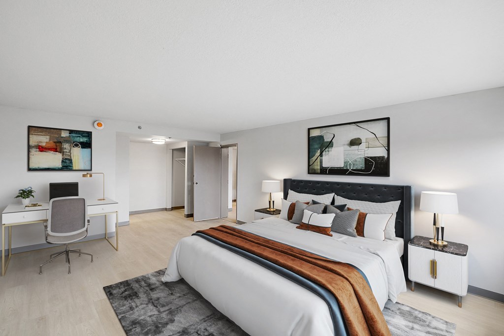 a bedroom with a large bed and a desk with a computer at The Block at Sterling Heights, Michigan, 48312