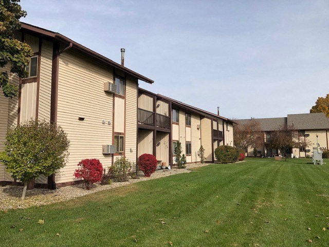 a group of houses with a grassy area in front of them
