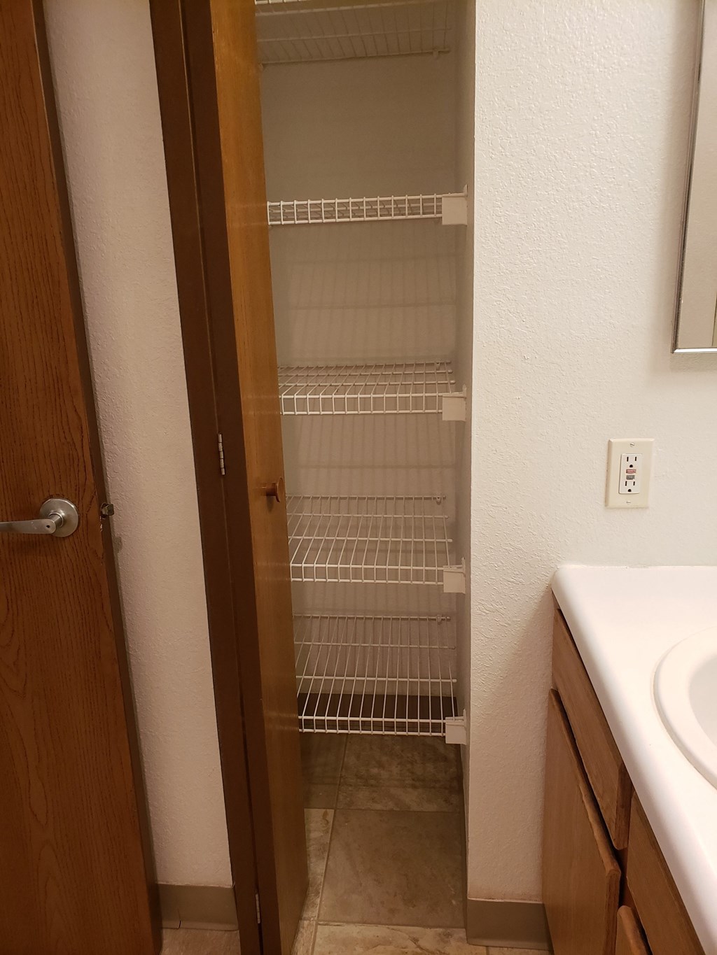an empty closet in a bathroom with a sink and a mirror