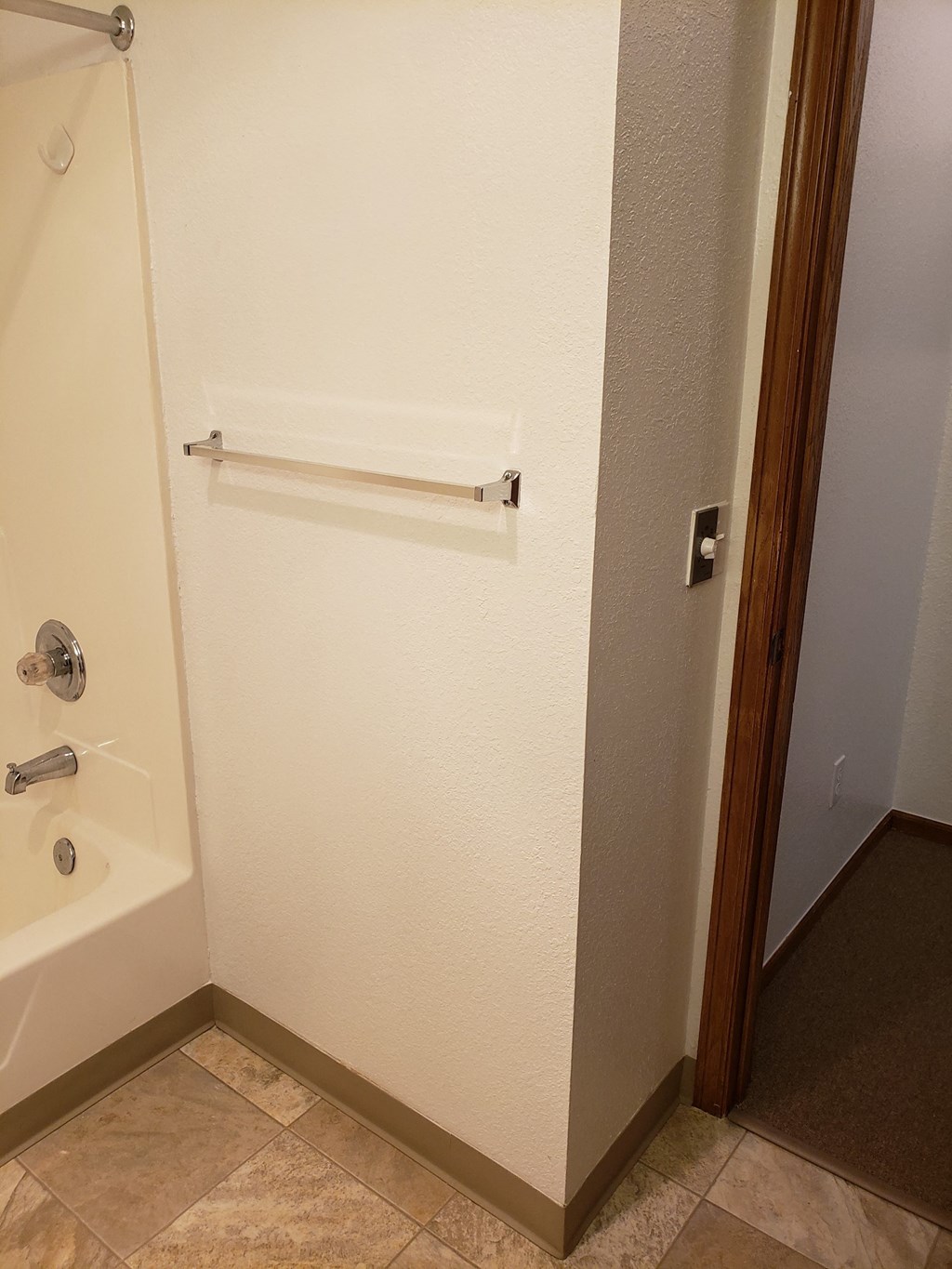 a bathroom with a bathtub and a towel rack