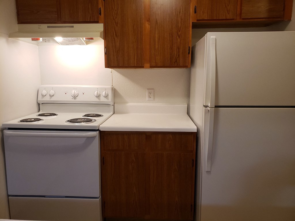 a kitchen with white appliances and wooden cabinets